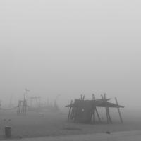 Strand und Spielplatz im Nebel, es sieht ein wenig aus wie gestrandete Schiffe im Nebel.